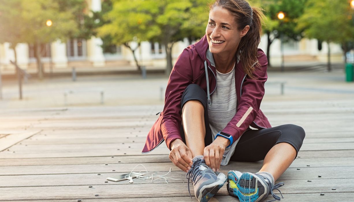 Joggerin bindet sich die Schuhe.