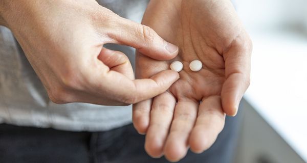 Zwei Tabletten in einer Hand.