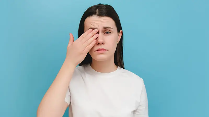 Frau, hält sich ein Auge.