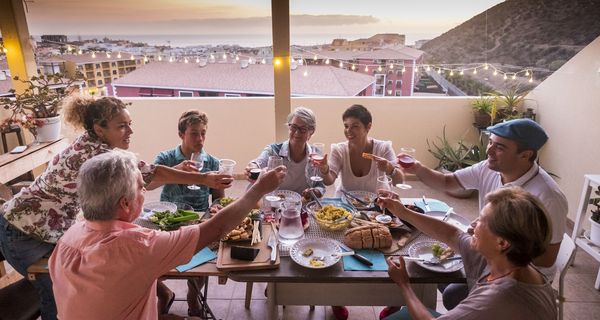 Großfamilie beim Essen auf der Terasse.