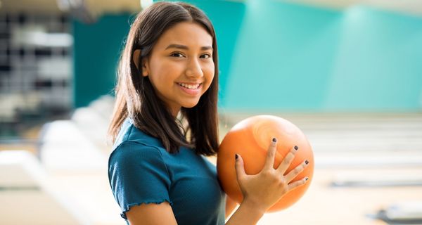 Junge Frau mit Bowlingkugel