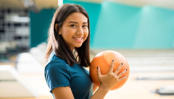 Junge Frau mit Bowlingkugel