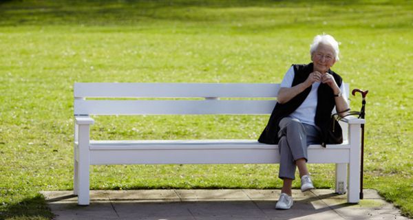 Alte Frau auf einer Parkbank