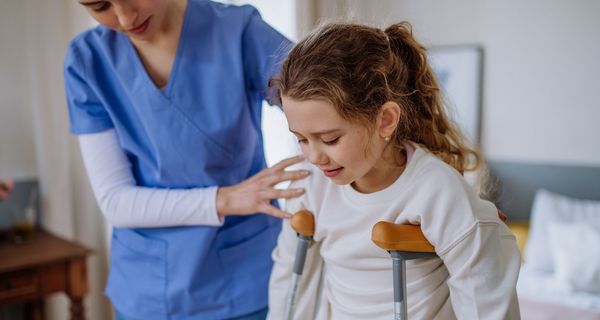 Kind, auf Krücken im Krankenhaus.