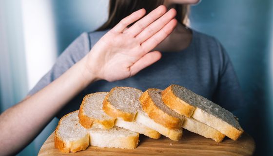 Frau, lehnt einen Teller mit Brot ab.