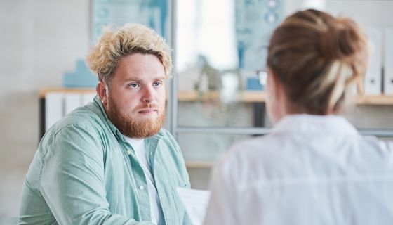 Junger Mann im Gespräch mit Ärztin.