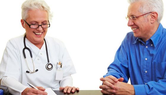 Ärztin spricht mit einem älteren Patienten