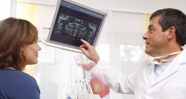 Zahnarzt erklärt Patientin ihr Röntgenbild