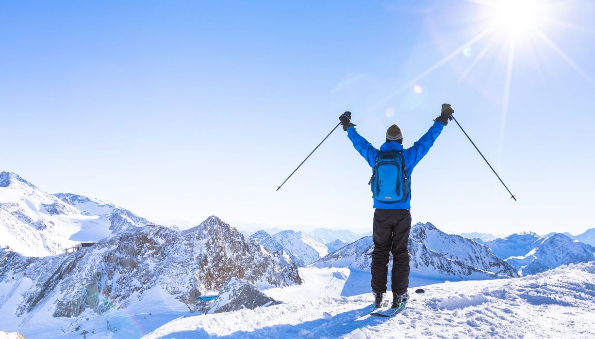 Skifahrer auf einem Berg mit Sonnenschein.
