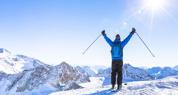 Skifahrer auf einem Berg mit Sonnenschein.