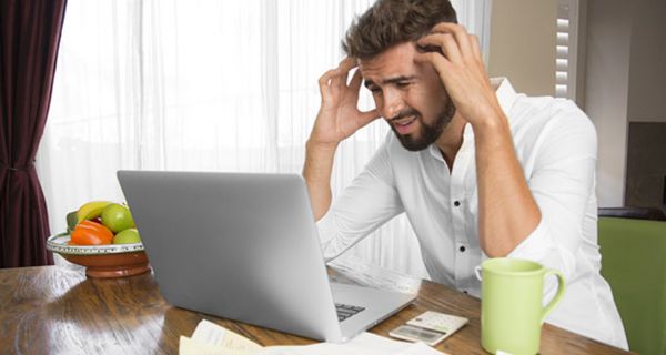 Junger gestresster Mann vor dem Computer.