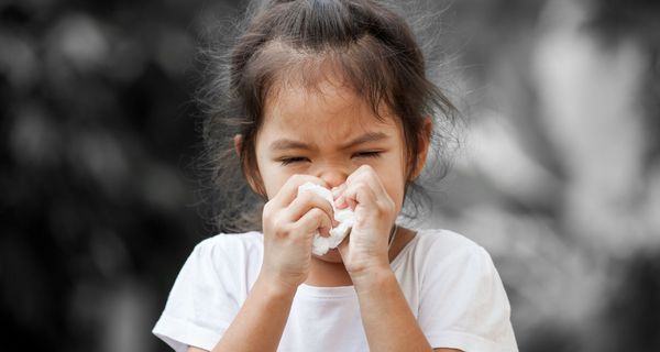 Mädchen, ca. 4 bis 5 Jahre alt, putzt sich die Nase.