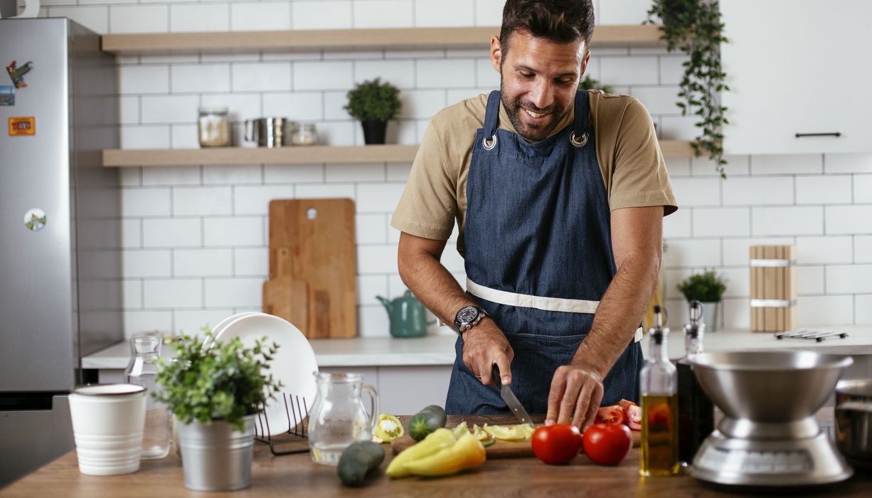 Mann schneidet Paprika mit einem Messer