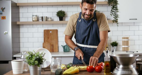 Mann schneidet Paprika mit einem Messer