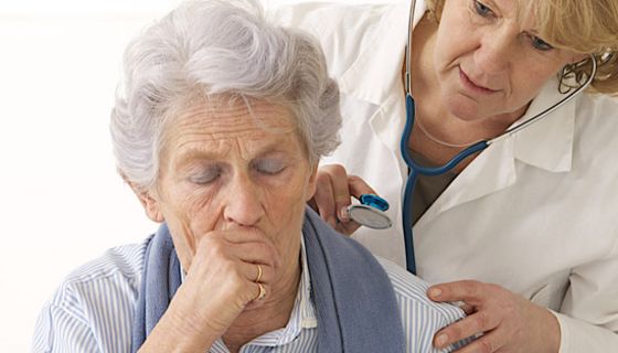 Seniorin hustet während Ärztin ihr den Rücken abhorcht