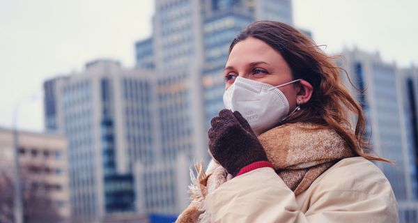 Frau mit Maske, im Winter in der Stadt.