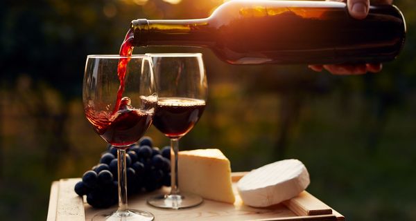 Käse und Wein werden eingeschenkt bei Sonnenuntergang