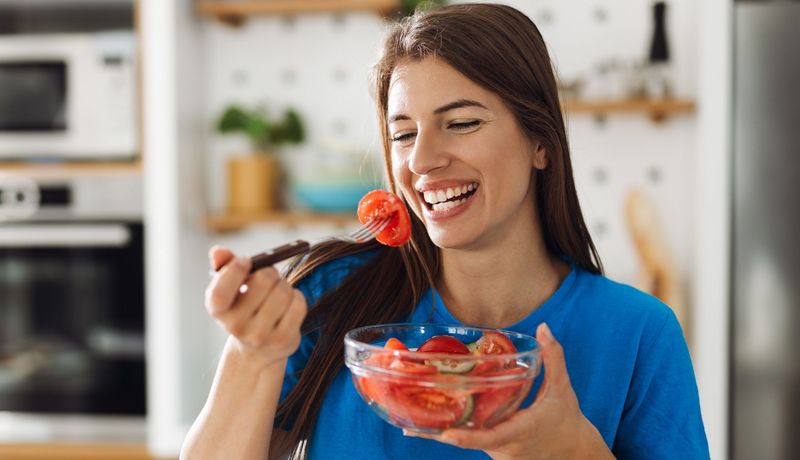 Eine Frau isst einen Tomatensalat.