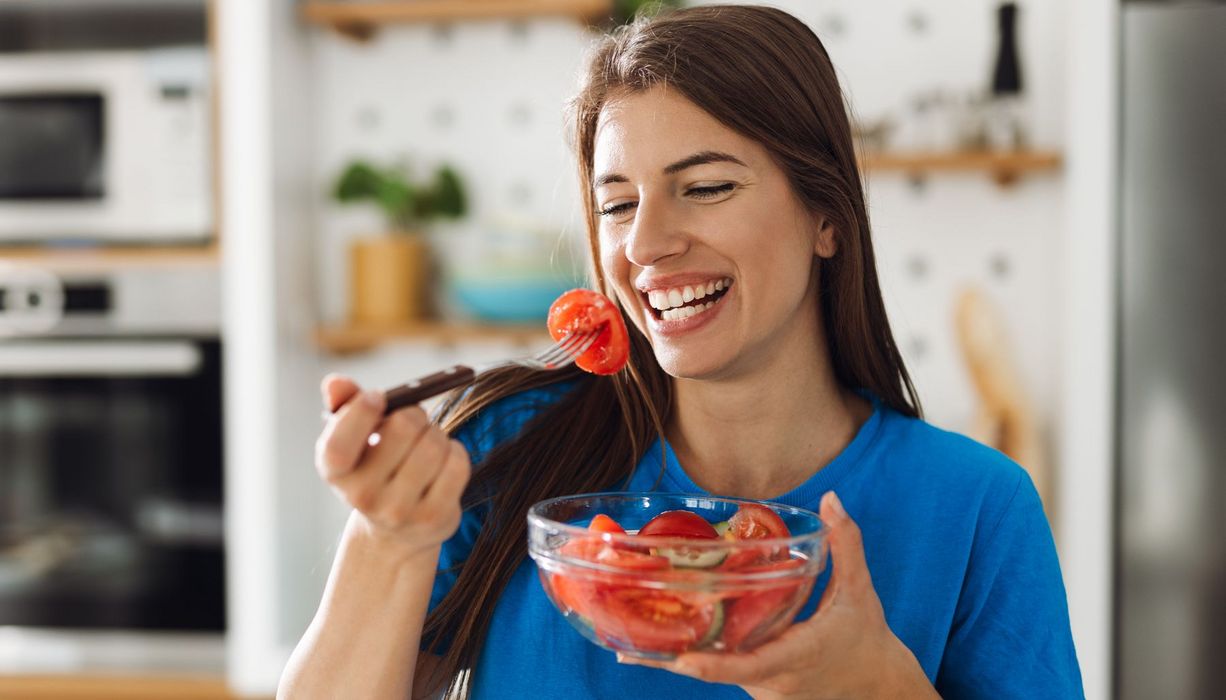 Eine Frau isst einen Tomatensalat.