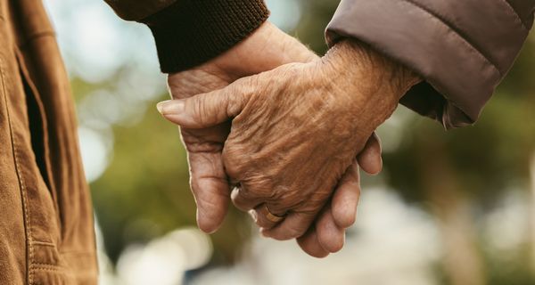 Zwei ältere Menschen, Hand in Hand.