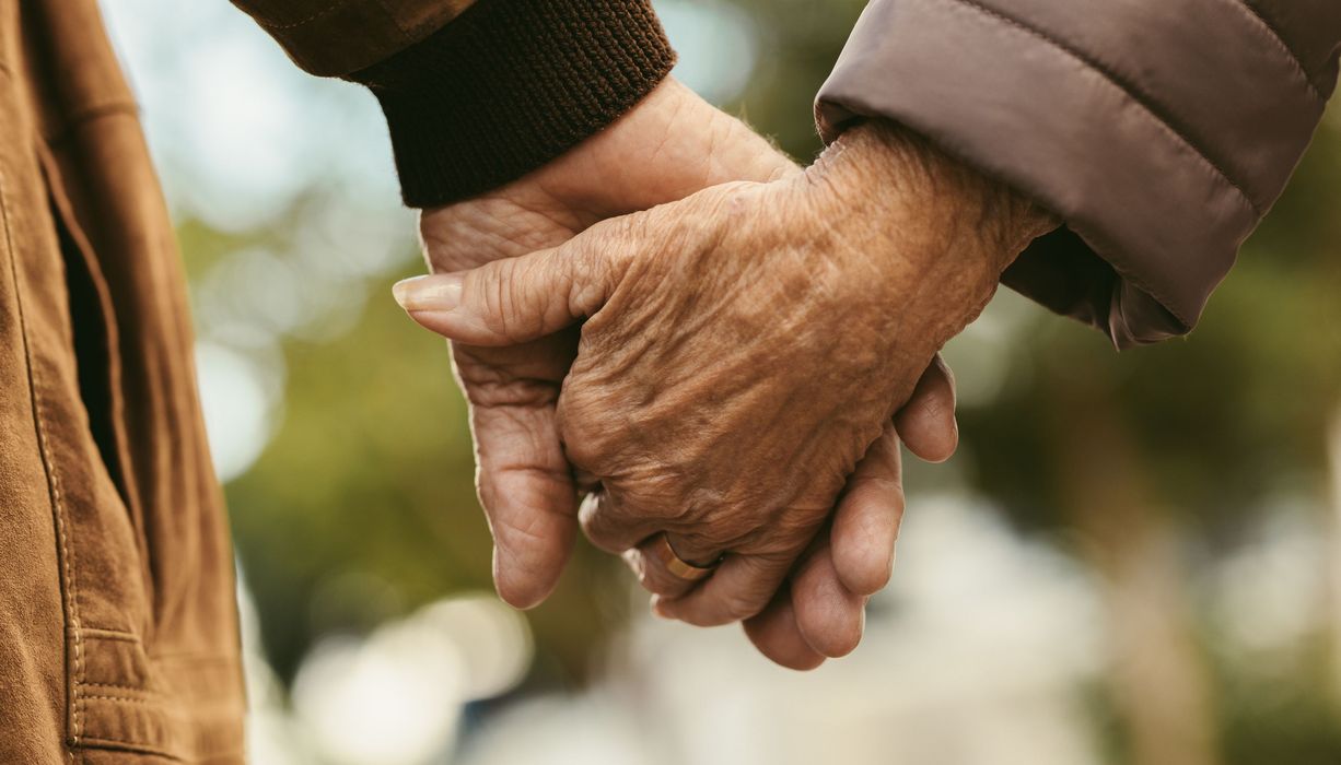 Zwei ältere Menschen, Hand in Hand.