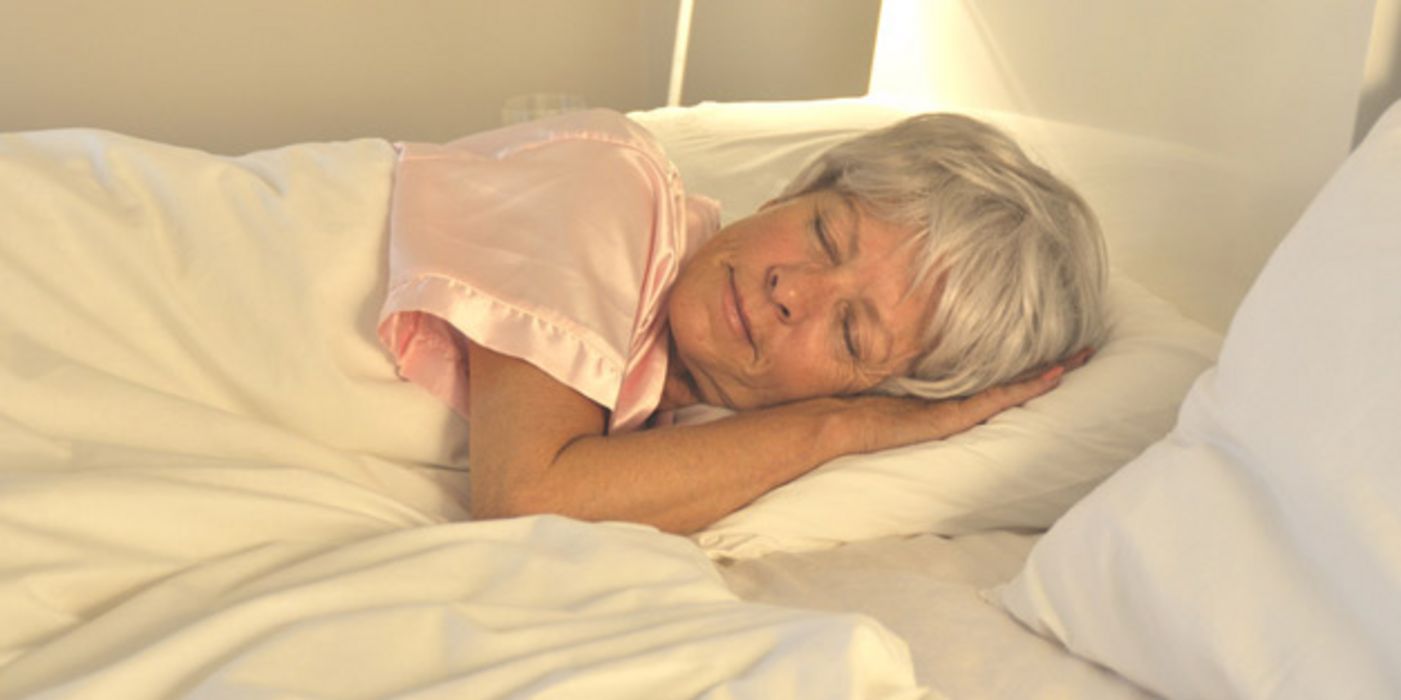 Frau schläft im Bett.