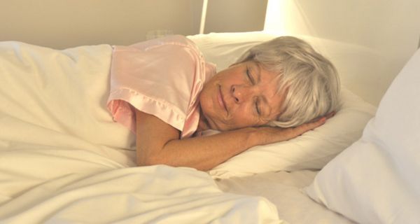 Seniorin schläft friedlich im Bett
