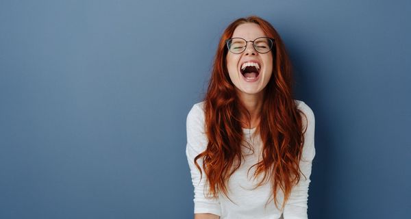 Junge Frau, schreit wütend und schaut in die Luft.