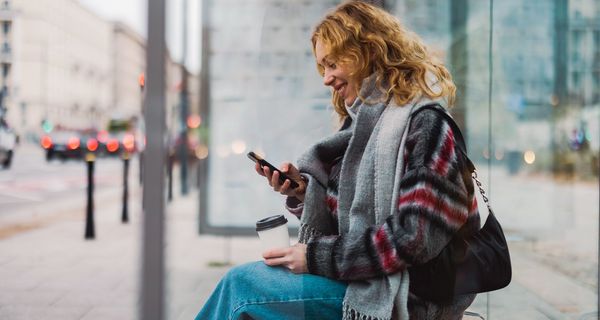 Junge Frau, schaut auf ihr Smartphone.