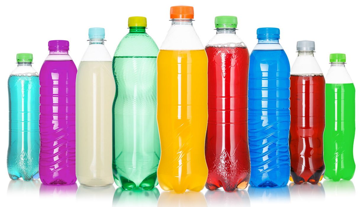Eine Reihe Plastikflaschen mit bunten Flüssigkeiten gefüllt.