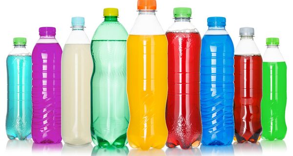 Eine Reihe Plastikflaschen mit bunten Flüssigkeiten gefüllt.