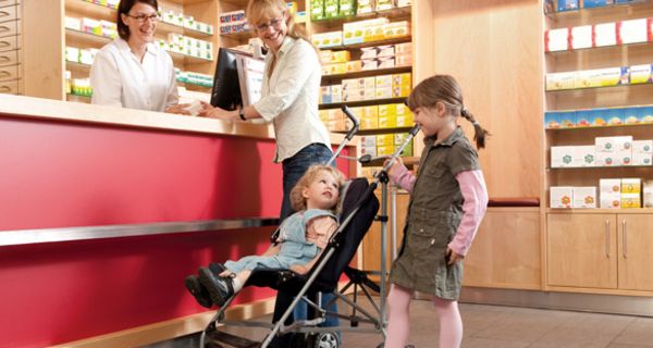 Junge Frau mit kleinen Töchtern in der Apotheke