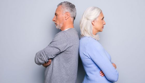 Mann und Frau, Rücken an Rücken mit verschränkten Armen.