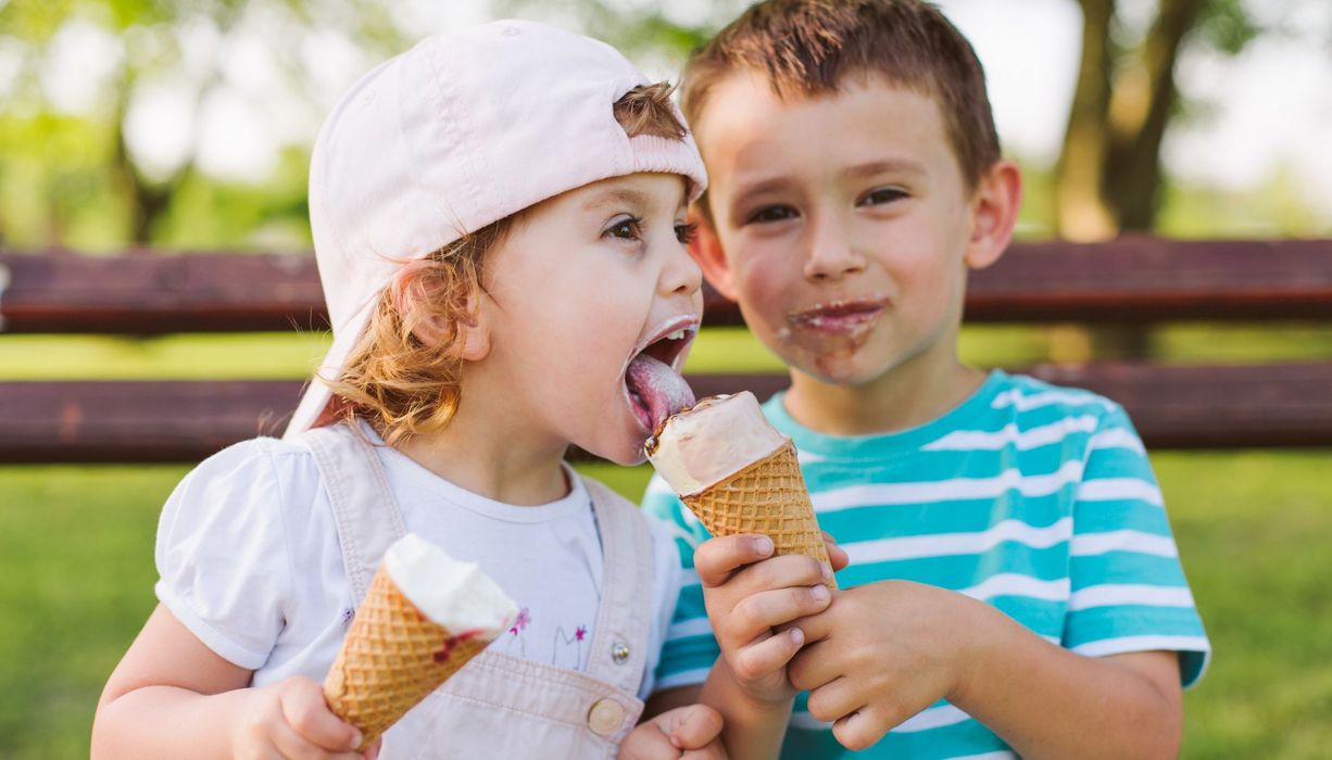 Junge und Mädchen, essen Eis zusammen.