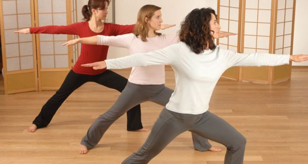 Drei Frauen machen Yoga.