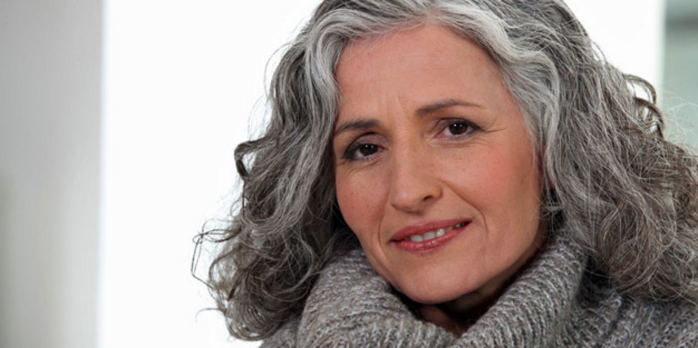 Ernst blickende Frau mit langen grauen Haaren