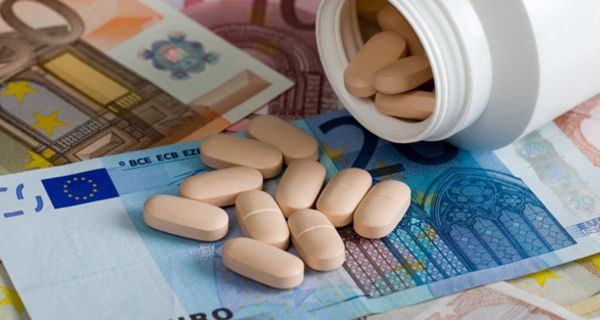 Plastikdose mit ausgeleerten Tabletten auf Euro-Scheinen