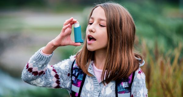 Mädchen, benutzt einen Asthma-Inhalator.