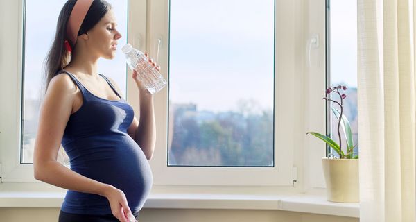 Schwangere Frau, trinkt Wasser.