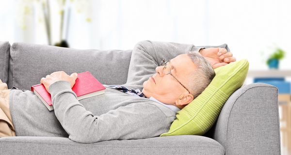 Mann schläft auf dem Sofa.