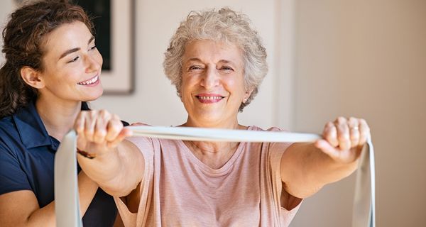 Physiotherapeutin zusammen mit einer älteren Frau.