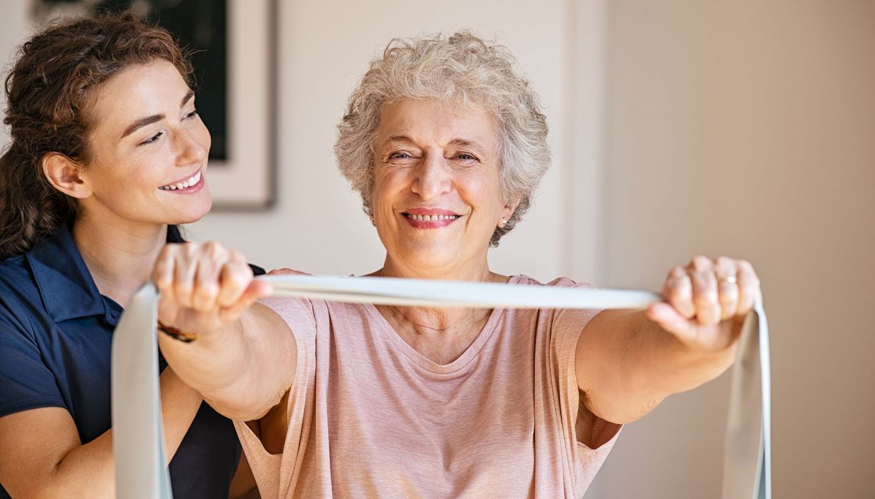 Physiotherapeutin zusammen mit einer älteren Frau.