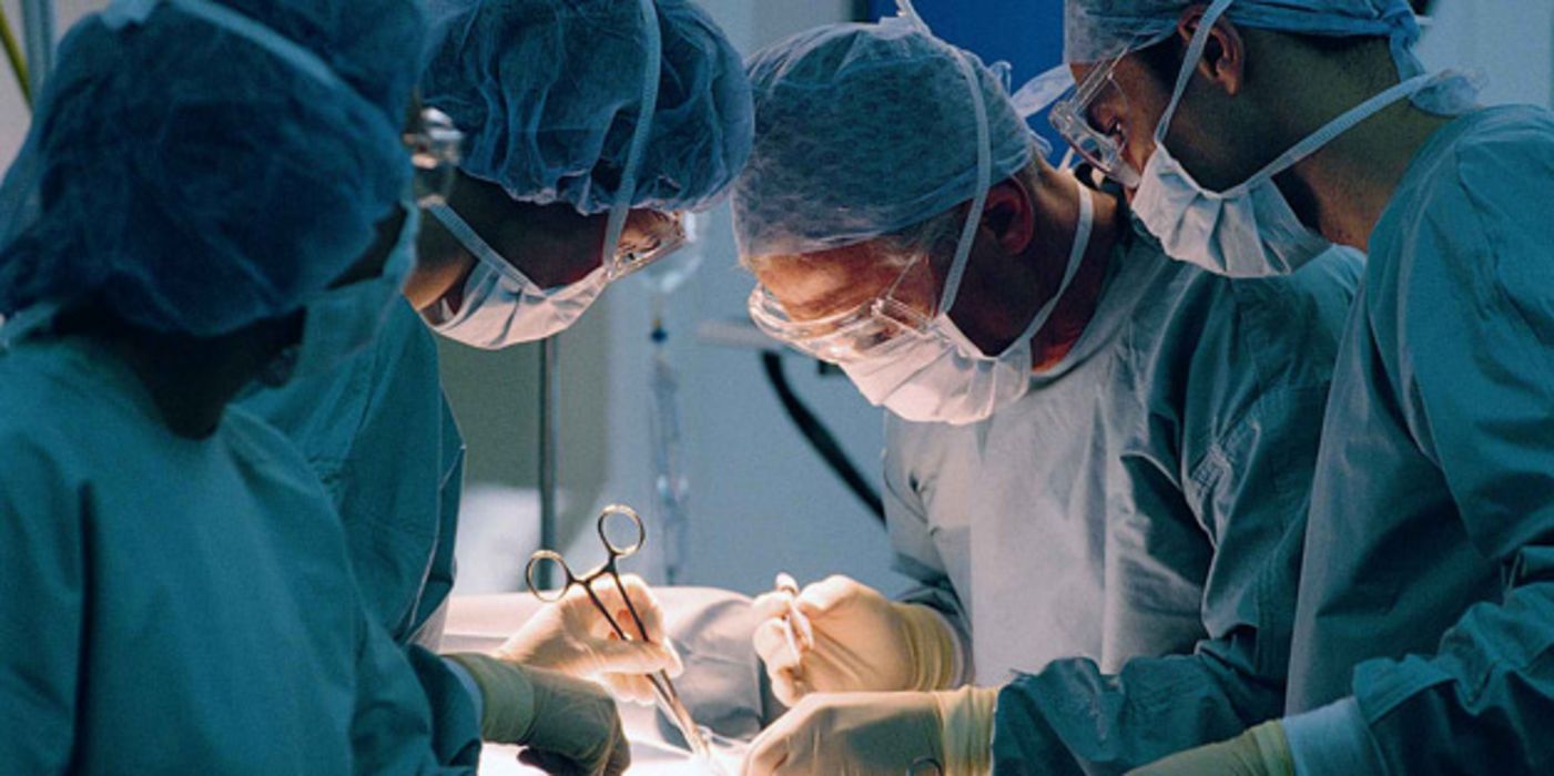 Ärzte beugen sich während einer OP über einen Patienten