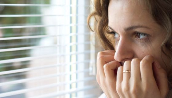 Verängstigte Frau am Fenster