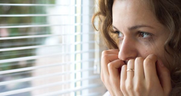 Verängstigte Frau am Fenster