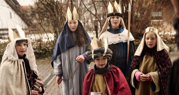 Gruppe von Sternsingern an der Haustür