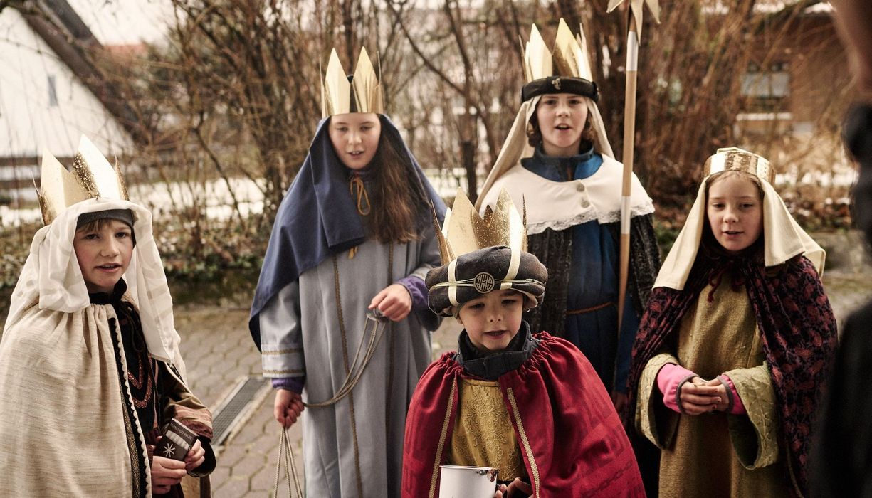 Gruppe von Sternsingern an der Haustür