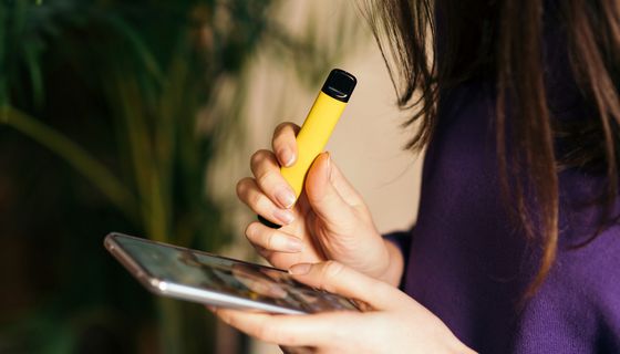 Frau, nutzt eine Einweg-E-Zigarette.