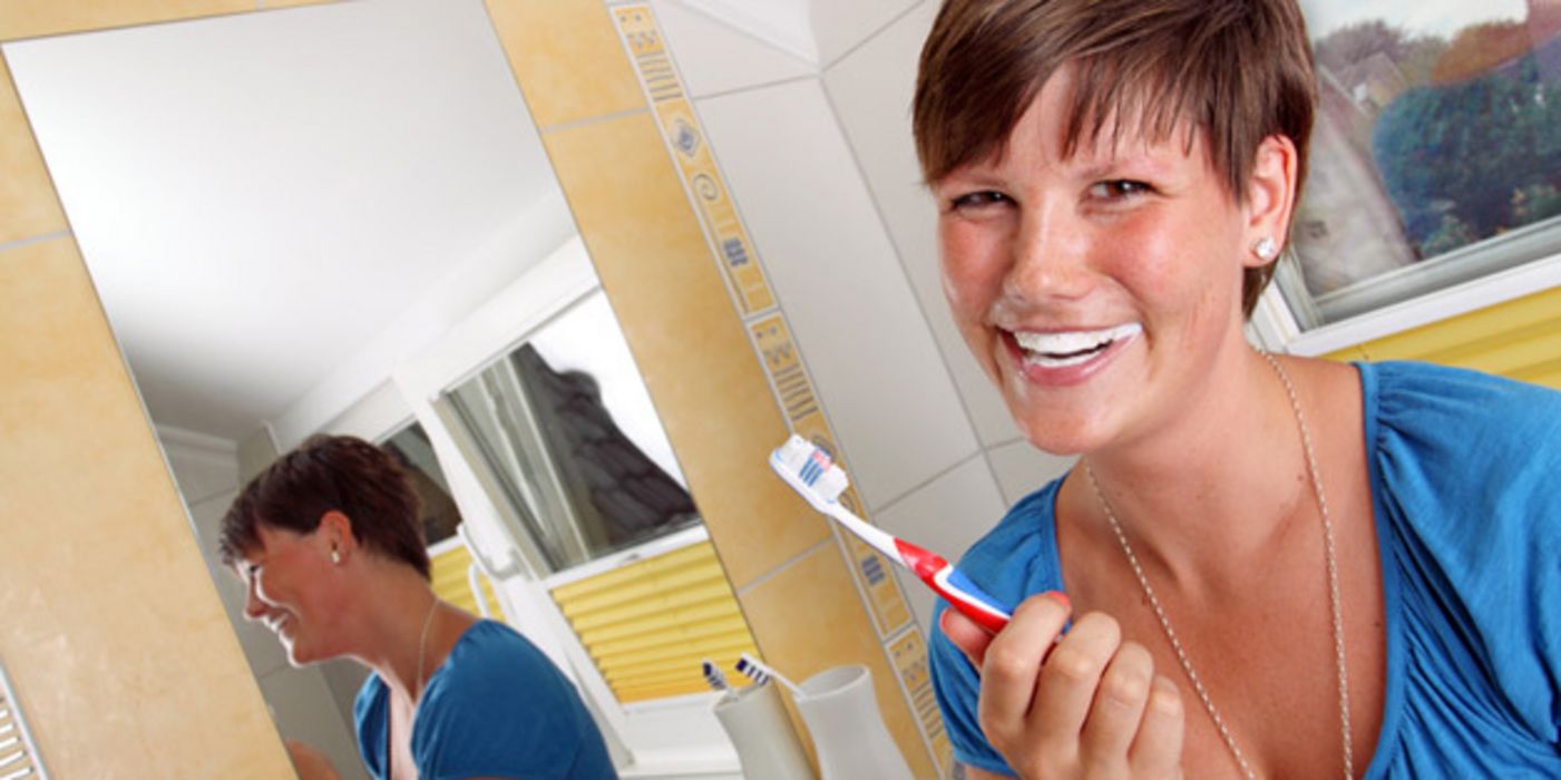 Frau putzt sich die Zähne.
