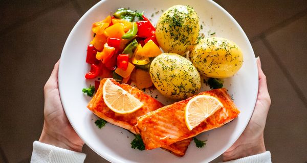 Teller mit Lachs, Kartoffeln und Gemüse.